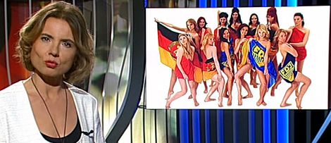 Moderatorin Tina Mendelsohn: »Nackte Ostalgie« Moderatorin Tina Mendelsohn, im Hintergrund Foto von Ensemble-Mitgliedern in FDJ- und DDR-Fahnen gehüllt.