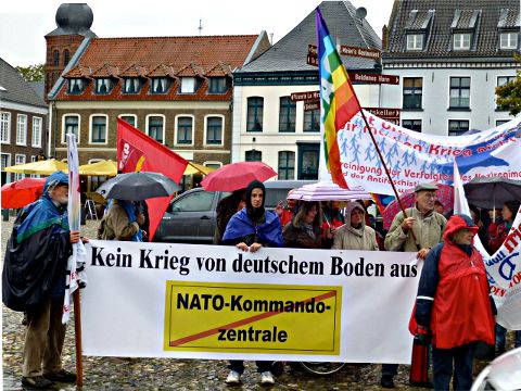 Kundgebung auf dem Marktplatz in Kalkar Demonstration mit Fahnen und Transparent: »Kein Krieg von deuschem Boden aus« und durchgestrichen: »NATO Kommandozentrale«.