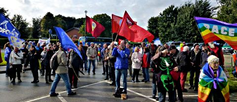 Demonstrantinnen und Demonstranten mit blauen, roten und bunten Fahnen.